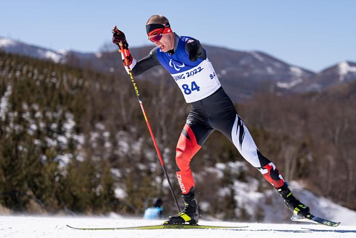 A male Para athlete is competing in Para cross-country skiing